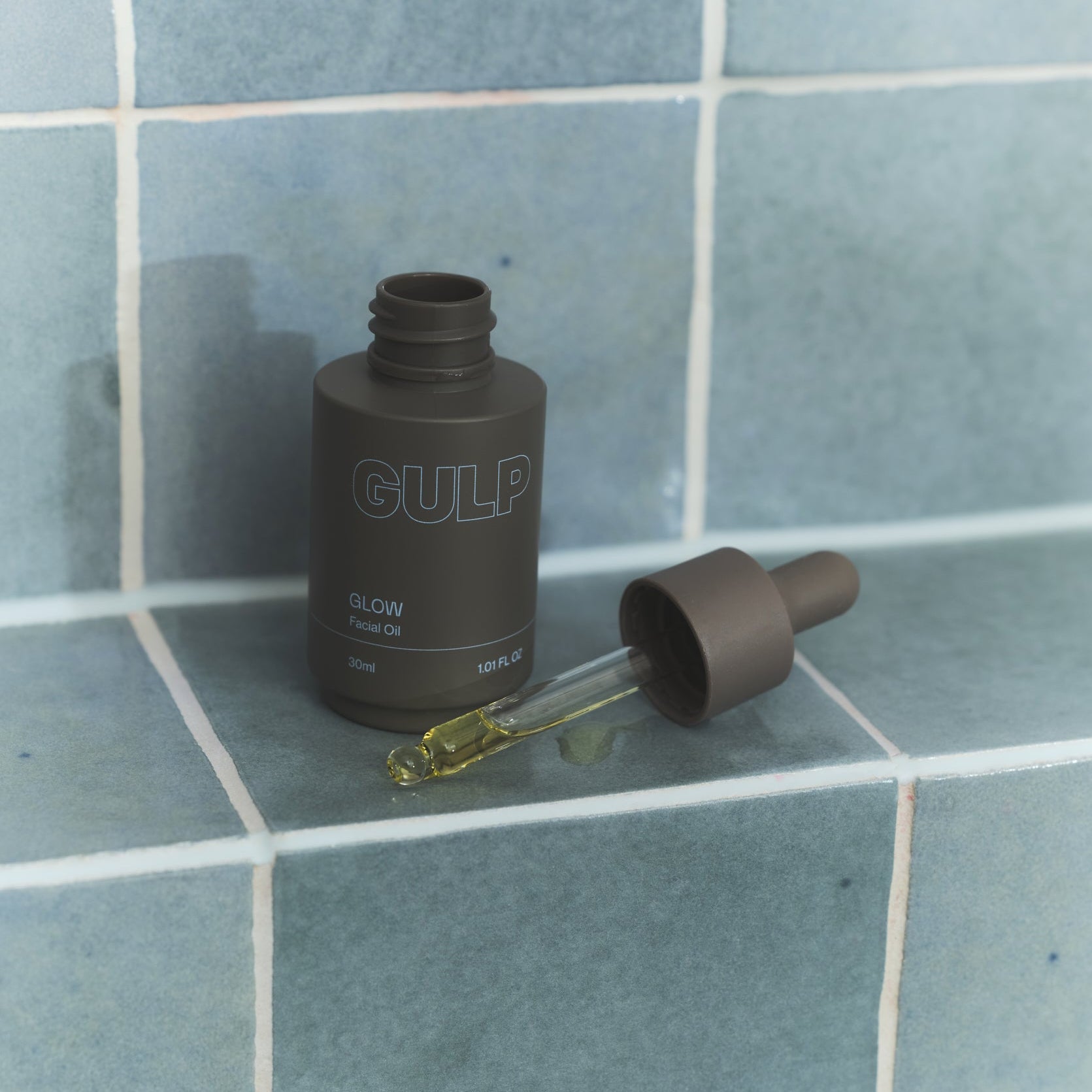 GULP bottle with dropper on a tiled surface