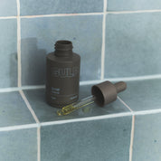 GULP bottle with dropper on a tiled surface