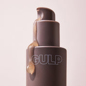 GULP Super Skin serum bottle with a beige cap on a light pink background