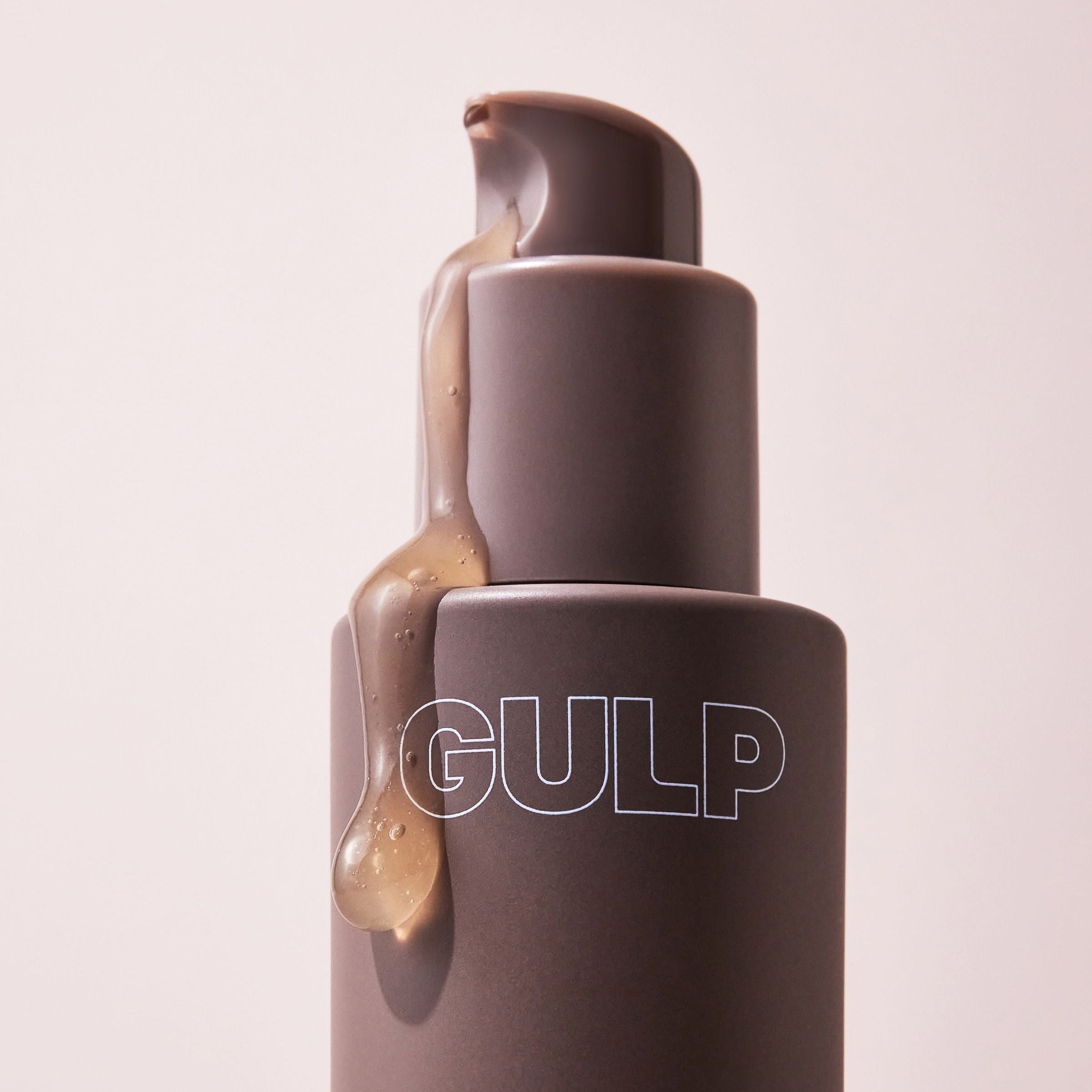 GULP Super Skin serum bottle with a beige cap on a light pink background